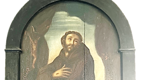 Franz von Asissi (1181/82 – 1226), mit den Attributen braune Kutte des Franziskanerordnens, Wundmalen (Stigmata) an der rechten Hand, Totenkopf in der linken Hand, Kruzifix links im Hintergrund. Barockes Ölgemälde auf Holz im Kreuzgang des ehem. Kapuzinerklosters Bacharach.